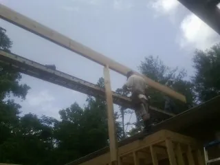 Carpenter setting a ridge beam over a new addition frame — Ice Dam Removal by Roofing Brothers in Rosholt